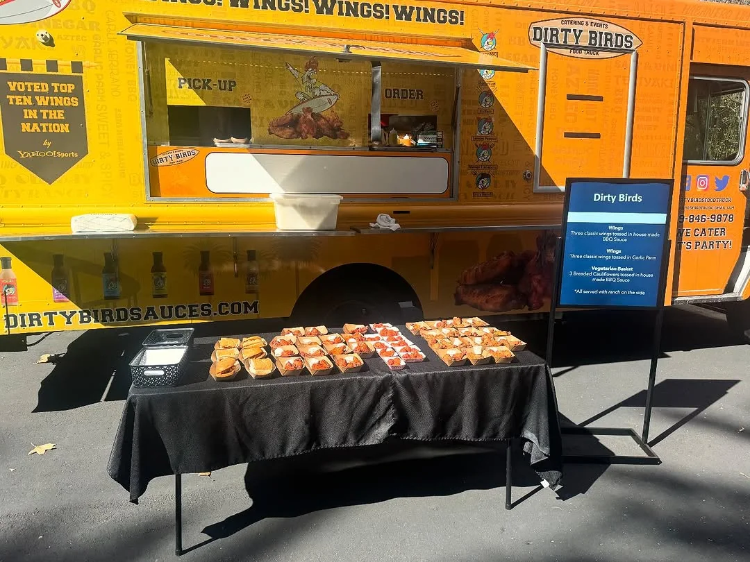 Dirty Birds truck with a catering table at an outdoor event